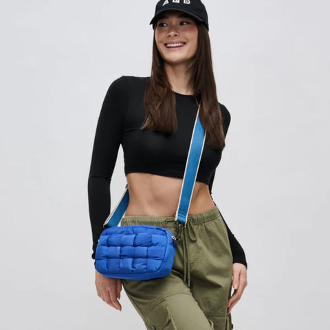 model carrying a blue crossbody bag