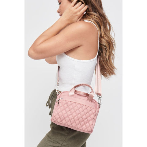 model with a light pink woven handbag