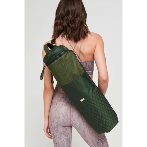 model carrying an olive green yoga mat bag across her back