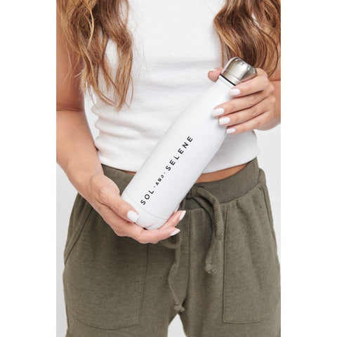 model holding a white stainless steel Sol and Selene water bottle