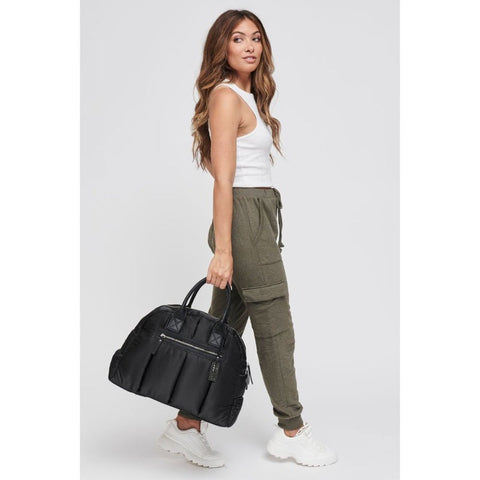 woman carrying a large black satchel purse