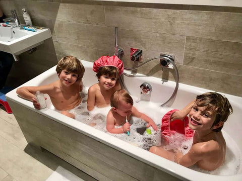 Baby and three siblings in the bath with sensitive bubble bath