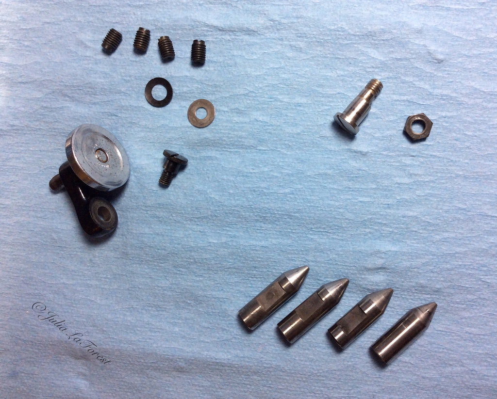 Singer Featherweight 221 rocker arm pins and extra parts after being cleaned in ultrasonic cleaner