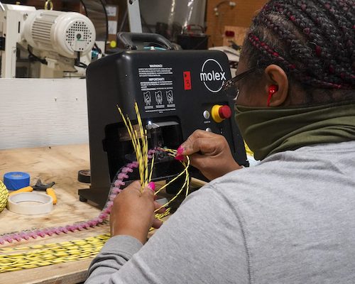 Photo courtesy Equalizer Systems. An employee working in the Harness Shop.