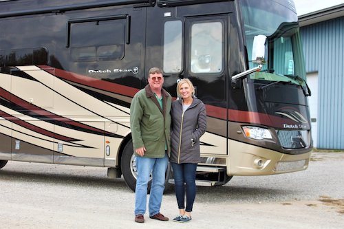 Photo courtesy of HWH Corporation. Happy customers in front of their Class A RV with an HWH leveling system installed.