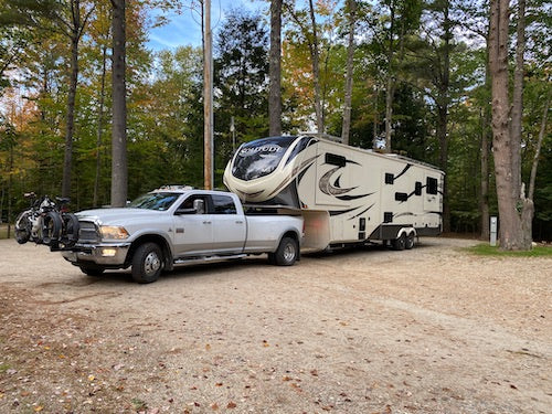 A large fifth wheel with a one-ton dually truck towing it.