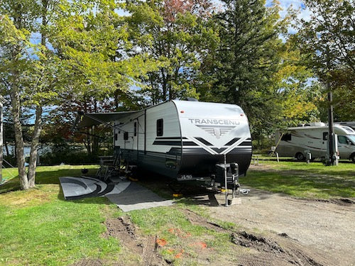 A travel trailer all set up for a weekend of camping.