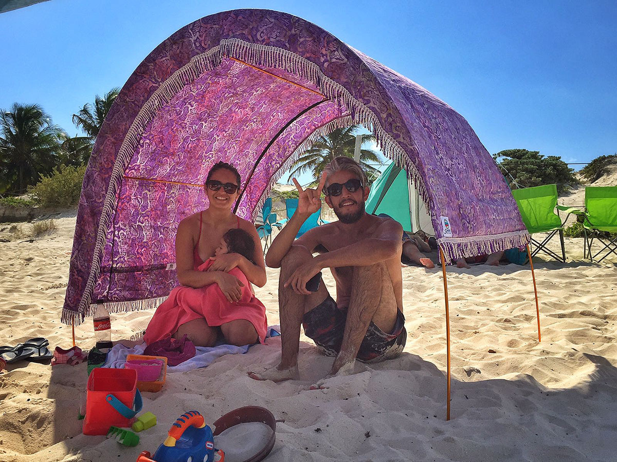 Family sits beneath arched Suniela Beach shade cabana in Mexico