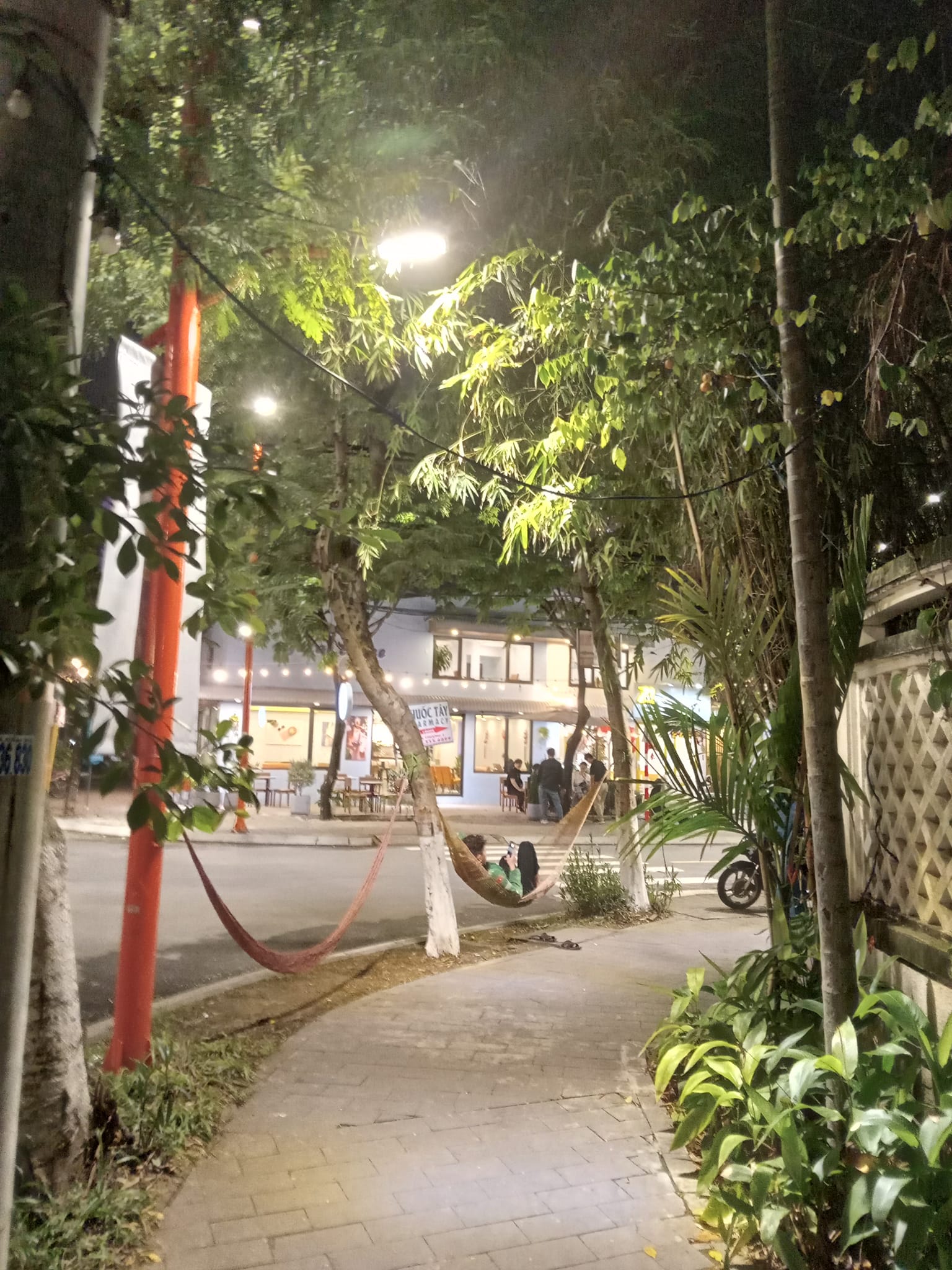 A man relaxes in a hammock strung along the sidewalk in Da Nang, Vietnam