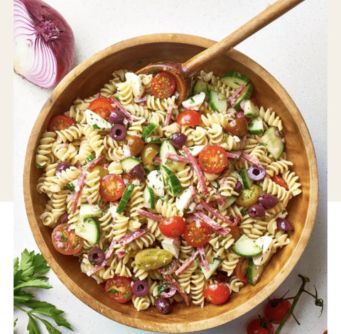 A pasta salad overhead view. Onion, pasta, parsley, tomatoes, cucumbers!