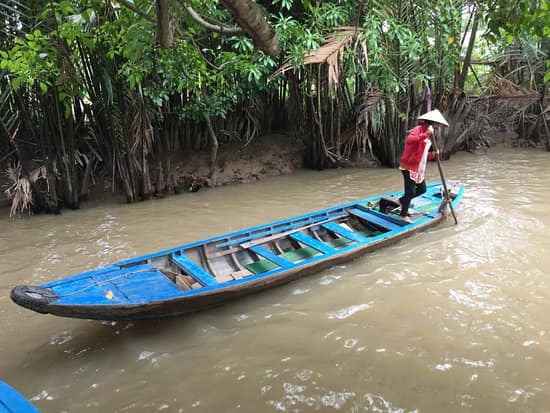 A woman stands on a traditional Sampan boat in Vietnam