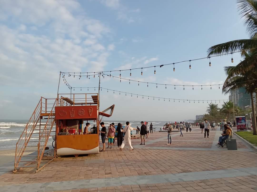 Food truck, patio lights and palm trees along the beach boardwalk of Da Nang, Vietnam