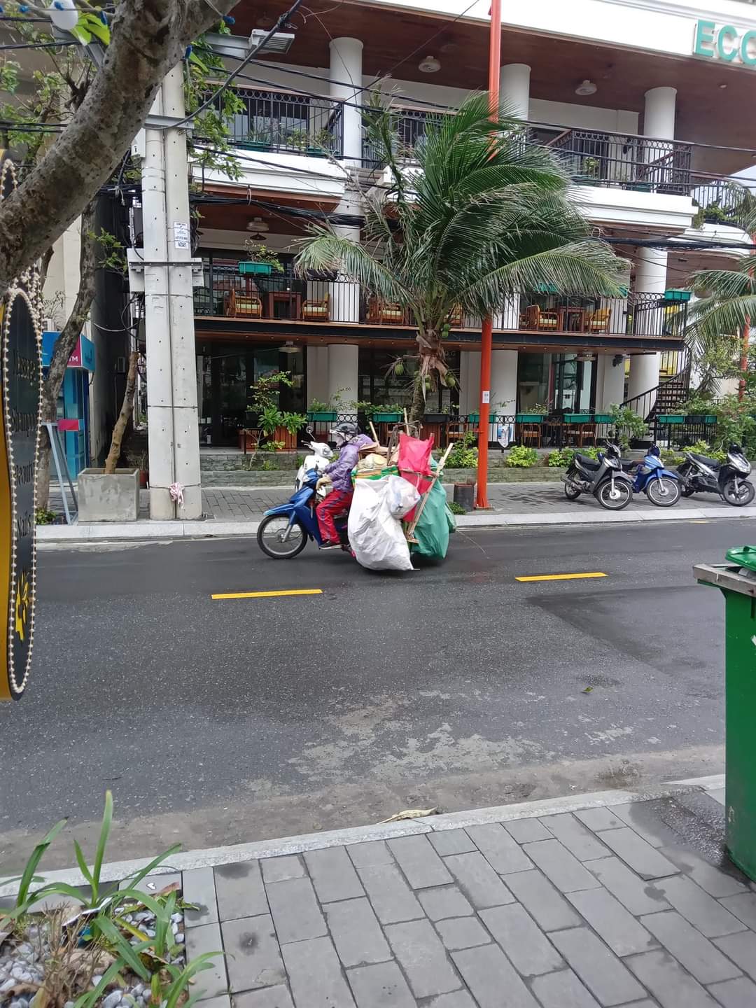 A woman carries many large bags on her scooter in Da Nang, Vietnam