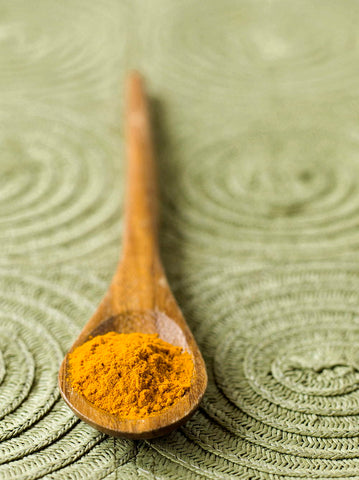 wooden spoon with ground turmeric