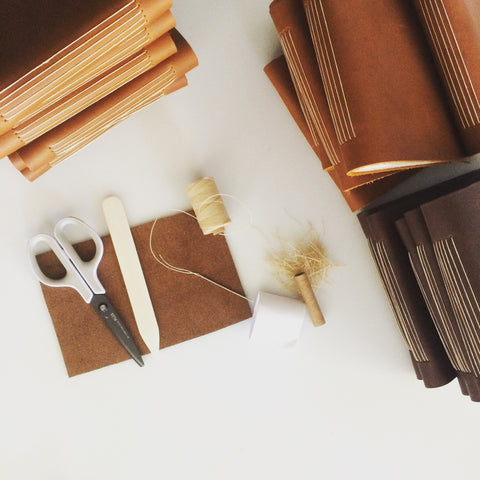 sewing together a handmade leather journal