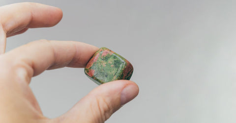 Hand holding unakite healing crystal