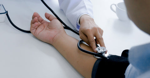 doctor checking patient blood pressure