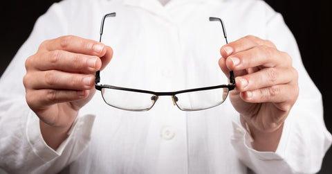 Person Holding a Pair of Eyeglasses