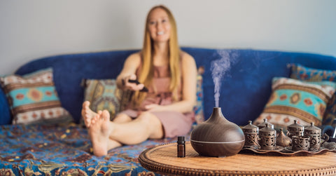 Woman relaxing at home with essential oil diffuser