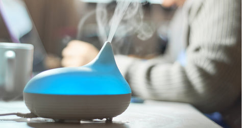 Woman uses aroma diffuser while working