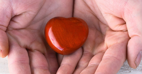 hand holding a heart shaped stone
