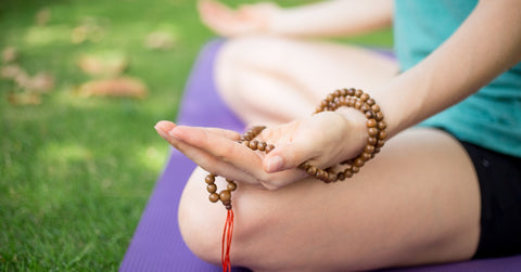 hand of meditatiing woman with mala beads