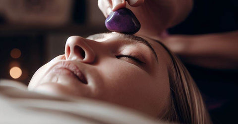 purple heaing stone on a woman's forehead