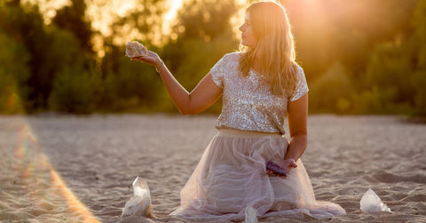 woman on beach holding healing crystals