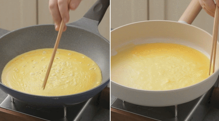 A looped animation depicting the preparation of an omelet with beaten eggs poured into a frying pan and gently stirred with a wooden spatula, highlighting the cooking process.