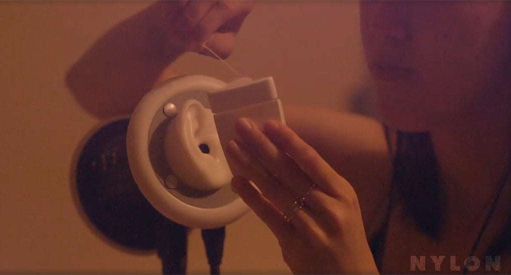 Image of woman using a floss dispenser in front of a 3Dio binaural microphone.