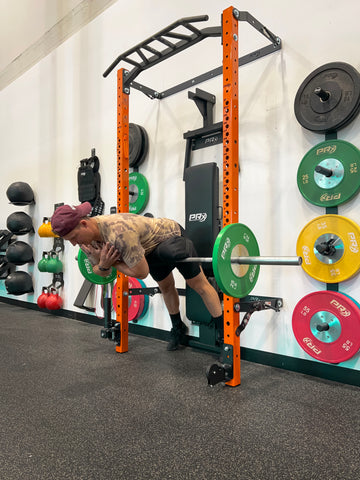 Man performing back extension hack on PRx Performance Folding Squat Rack