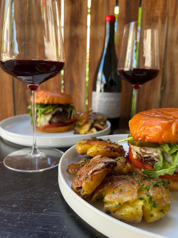 A juicy burger in front of a glass of Beaujolais