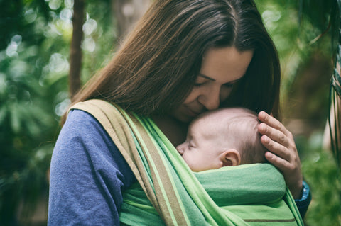 Mum snuggling baby in carrier