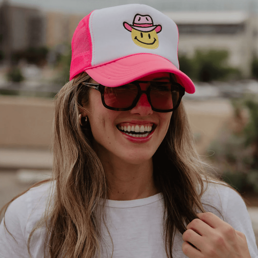 A woman wearing a cowgirl-themed foam trucker hat