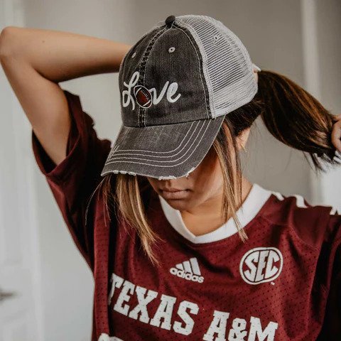 woman wearing a love football hat and Texas A&M jersey
