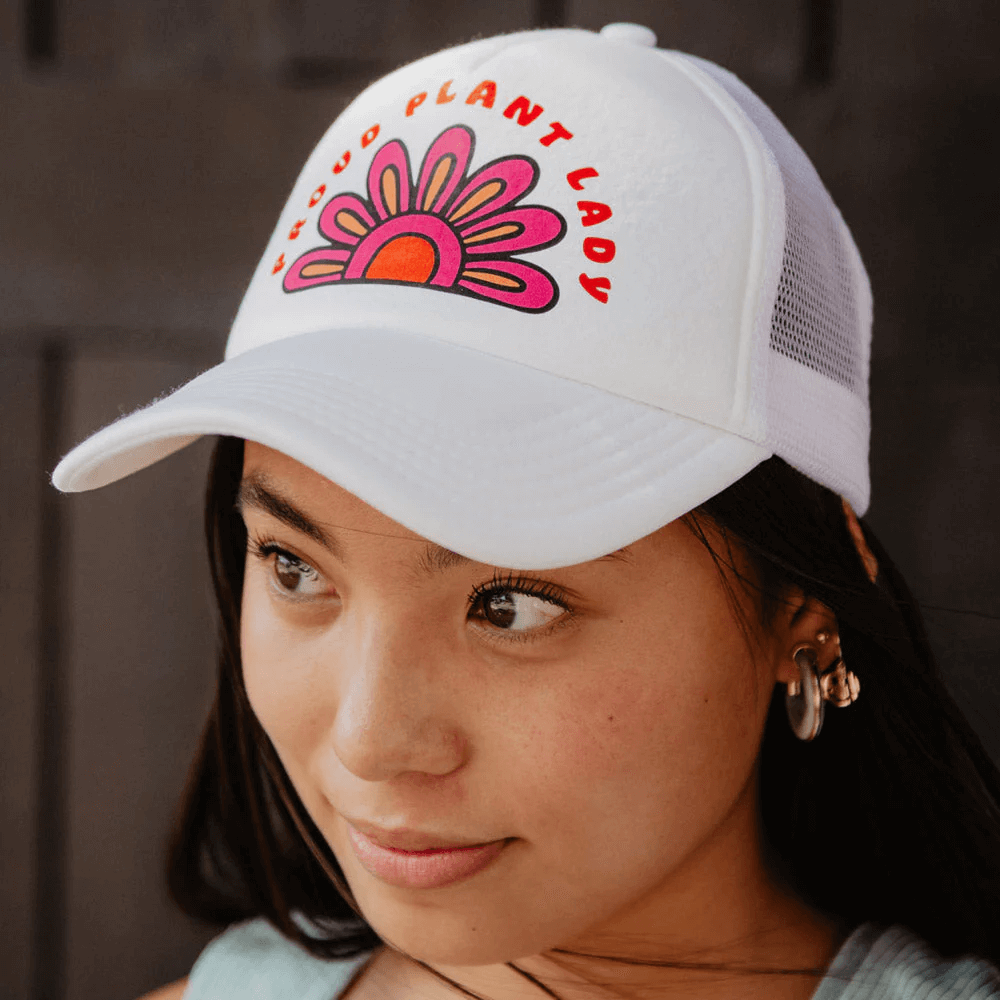 A woman wearing a cute Mother's Day gifts white trucker hat that says “Proud Plant Lady”