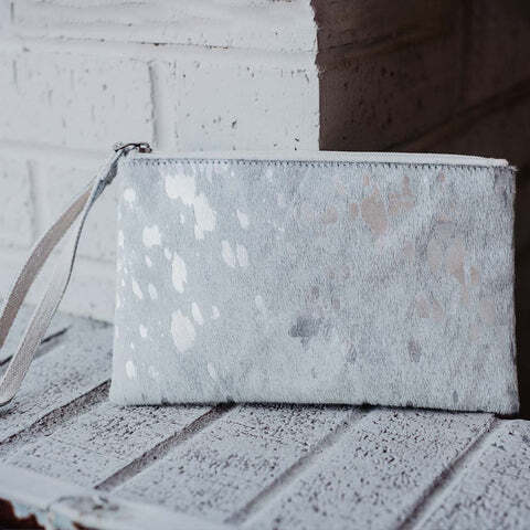 silver wristlet leaning against a wall