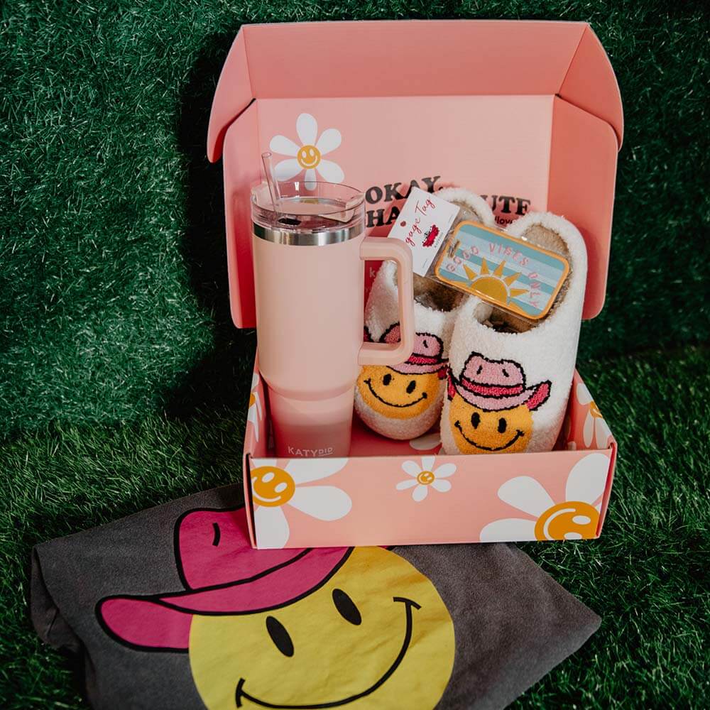 A Western cowgirl trends gift box containing cowgirl-inspired slippers, tumbler, and a luggage tag