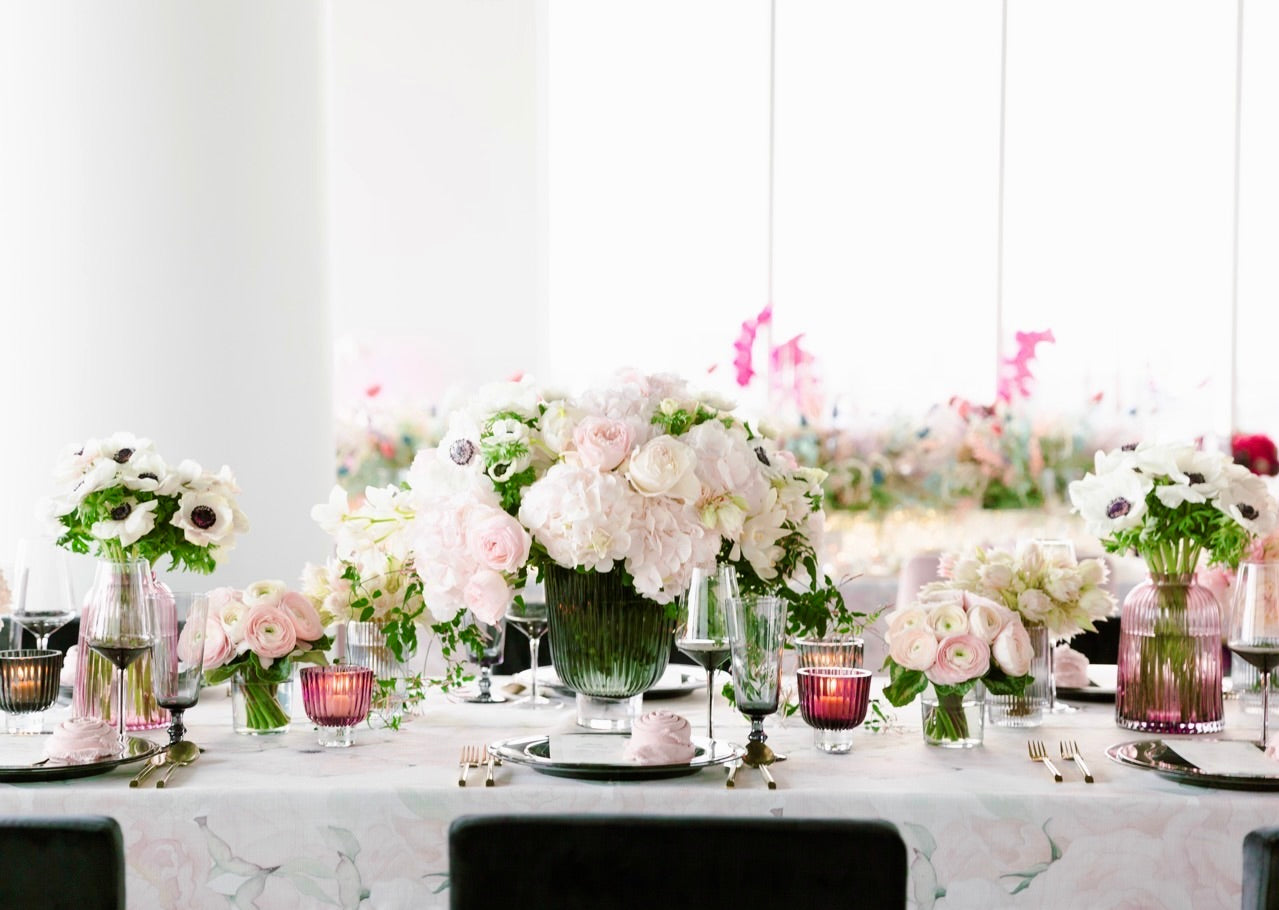 Hydrangea and anemones in pink tones designed on vases on a table