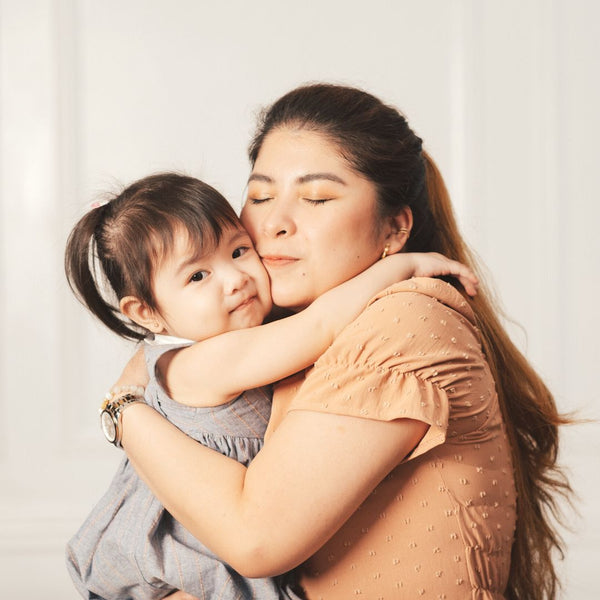 A Filipino mother & daughter hugging tightly.