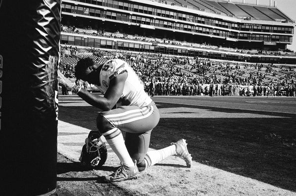 football player kneeling by Daniel Alvarez