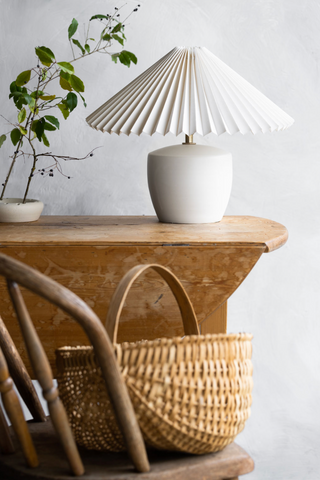 Notary Ceramic lamp on a wooden table with a green stem in a small vase