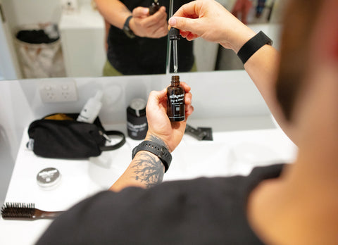 Man dispensing beard oil