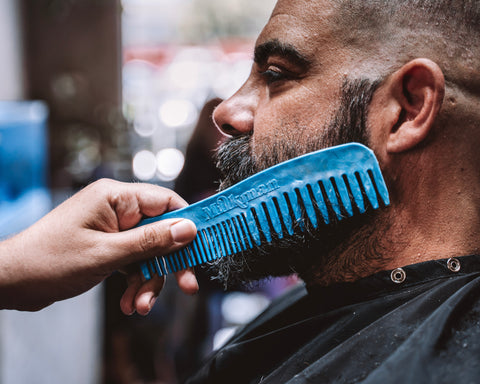 barber using enviro comb recycled plastic comb on a bearded man