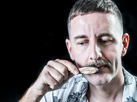 man brushing moustache with a moustache brush