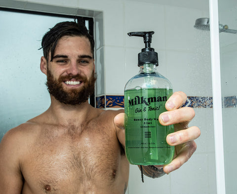 bearded man holding gin and tonic body wash shampoo & conditioner