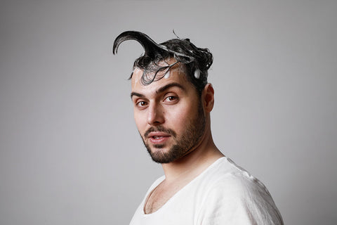 man with too much hair product styling his hair into a horn