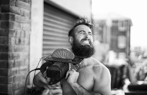 man chopping beard with saw