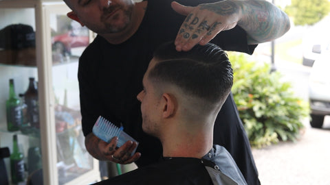 barber styling man's hair with pomade