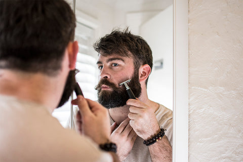 man shaving the cheek lines on his beard